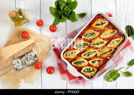 Lecker große pasta Muscheln gefüllt mit Käse und Spinat und gebacken mit Sauce marinara, Ansicht von oben, close-up Stockfoto