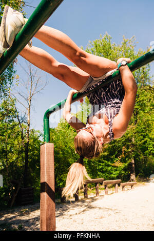 Schöne fitness Frau tun Übung auf Bars Sonnige outdoor Stockfoto