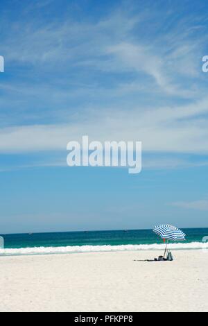 Brasilien, Rio de Janeiro, Regenschirm auf einsamen weißen Sandstrand in der Nähe von Cabo Frio Stockfoto