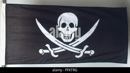 Totenkopf mit gekreuzten Knochen auf klassischen Piraten Flagge. Stockfoto