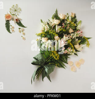 Ein Bukett von Pfirsich Blumen einschließlich der Snapdragons, Lilien, Rosen, gelb Fenchel und grünen Bracken. Stockfoto