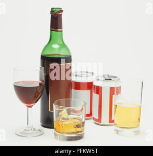 Selection of alcoholic drinks including bottle and glass of red wine, two tins of beer and glass half filled with beer, whisky glass containing ice cubes. Stockfoto