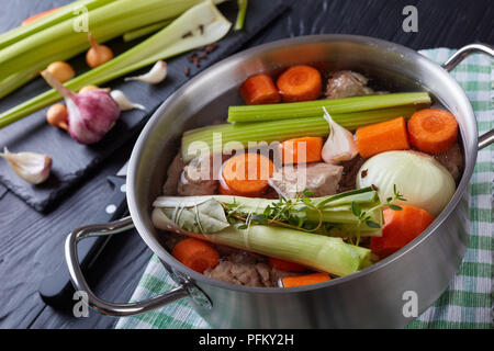 Zutaten für Kalbfleisch Eintopf oder Blanquette de veau - in Brühe Stücke von Kalbfleisch in Kasserolle mit bouquet garni und Gemüse gekocht. selleriestangen ein Stockfoto