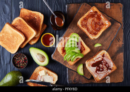 Herzhafte Toast zum Frühstück mit Butter, Avocado-, Scheiben und gesunde Lebensmittel verbreiten von übrig gebliebenen Brauereien Hefe mit Gemüse und Gewürze Extrakt, v Stockfoto