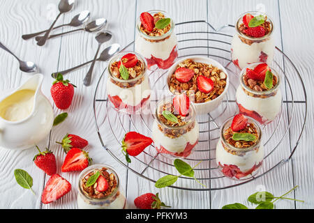 In der Nähe von köstlichen hausgemachten Müsli mit frischem Joghurt und reife Erdbeeren in Teil Gläser Metallgitter geschichtet, horizontale Ansicht von oben Stockfoto
