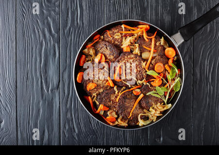 Lecker Huhn Leber Pfannkuchen geschmort mit Karotten, Zwiebeln und Kräutern in einer Pfanne, Ansicht von oben, flach Stockfoto