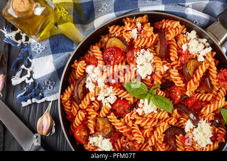 Vegetarische italienische Pasta Fusilli alla Norma mit Auberginen, Tomaten, Basilikum, ricotta Käse und marinara Sauce in einer Pfanne mit Inhaltsstoffen in der Bac Stockfoto