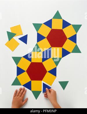 Boy's Hände, Quadrat, Dreieck und Sechskant Stücke zusammen, erstellen Muster Stockfoto