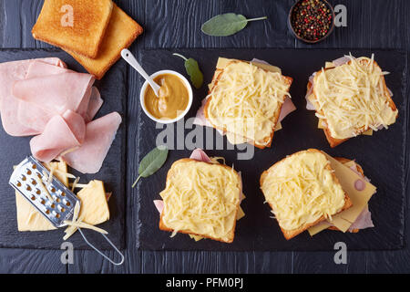 French Toast Croque Monsieur vorbereitet zu backen. geröstetes Brot mit Butter Scheiben gekochten Schinken und Emmentaler Käse auf ein Backblech und Zutaten o Stockfoto