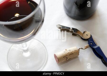 Korkenzieher mit Cork neben Glas Rotwein Stockfoto