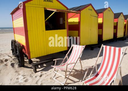 Belgien, De Panne, altmodisch bunten Badekabinen und gestreifte Liegestühle am Strand Stockfoto