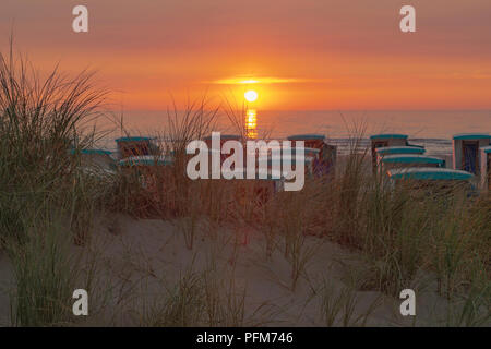 Kabinen am Strand mit herrlichen Blick auf den Sonnenuntergang über der Nordsee in Katwijk aan Zee, Nordholland, Niederlande. Stockfoto