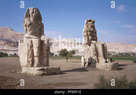 Ägypten, Thebes-Luxor, zwei Kolosse von Memnon Statuen ursprünglich Teil der Totentempel von Amenophis III (1417-1379 v. Chr.), die durch die überschwemmung Wasser des Nil und ein Erdbeben beschädigt. Stockfoto