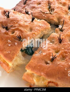 Focaccia farcita, mit Käse und Basilikum gefüllt und gekrönt mit Rosmarin und Meersalz Stockfoto