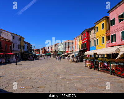 Touristen schlendern Sie zu den Geschäften und Cafes auf dem Hauptplatz auf der Insel Burano, Italien Stockfoto