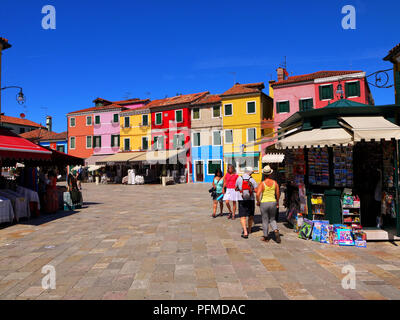 Touristen schlendern Sie zu den Geschäften und Cafes auf dem Hauptplatz auf der Insel Burano, Italien Stockfoto