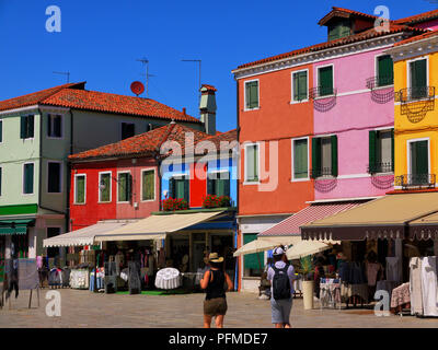 Touristen schlendern Sie zu den Geschäften und Cafes auf dem Hauptplatz auf der Insel Burano, Italien Stockfoto