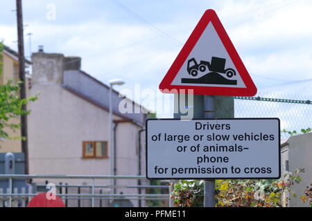 Ein Schild an einem Bahnübergang die Triebfahrzeugführer von langsamen und anormale laden Fahrzeuge Telefon das Signal, um die Erlaubnis zu überqueren. Stockfoto