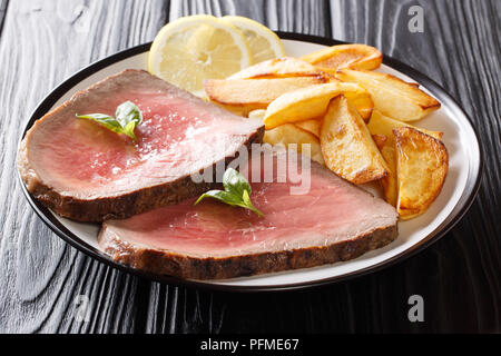 American beef steak mit einem gebratenen Kartoffelscheiben close-up auf einem Teller auf dem Tisch. Horizontale Stockfoto