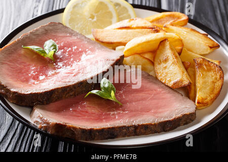 Geschnetzeltes Rindfleisch Steak mit einem gebratenen Kartoffeln close-up auf einem Teller auf dem Tisch. Horizontale Stockfoto