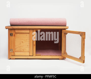 Holz- Tier Hutch, aufgerollt Teppich auf der Oberseite Stockfoto