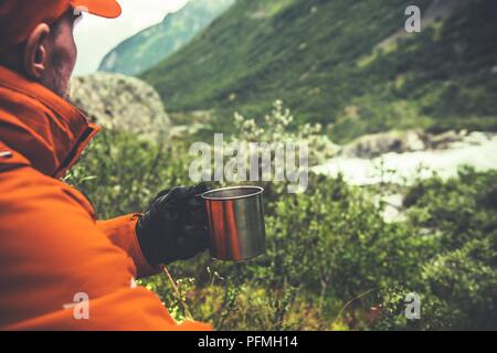 Kaukasische Wanderer in seinem 30s genießen Sie heißen Tee und das Vista auf dem Berg Trail. Stockfoto