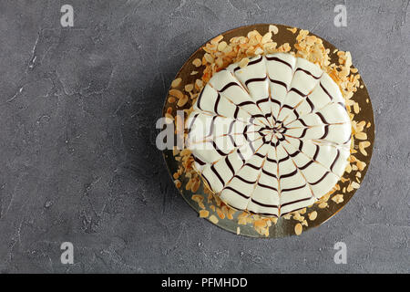 Köstliche esterhazy Torte bestreut mit mandelflocken auf eine goldene Platte auf konkrete Tabelle, authentische Rezept, ungarische und österreichische Küche, Aussicht her Stockfoto