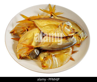 Köstlich kalt geräuchert Mond Fische mit goldenen Haut auf weißen platter auf weißem Hintergrund, Ansicht von oben, close-up Stockfoto