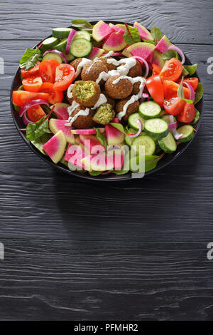 Leckere falafel Kugeln auf Platte mit Gemüse bunter Salat von Wassermelone Rettich, Mangold Blätter, Gurken- und Tomatenscheiben, gesunde Ernährung anhand von quantitativen Simulatio Stockfoto