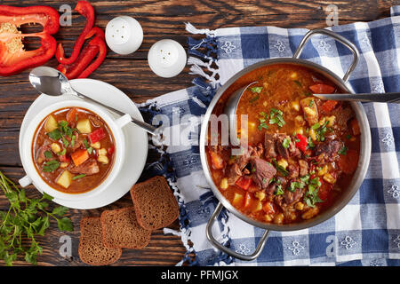 Hot Rindfleisch ungarischen Gulasch oder bograch Suppe serviert in einem zwei Griff weiß Suppenteller auf Holztisch, klassisches Rezept, Ansicht von oben Stockfoto