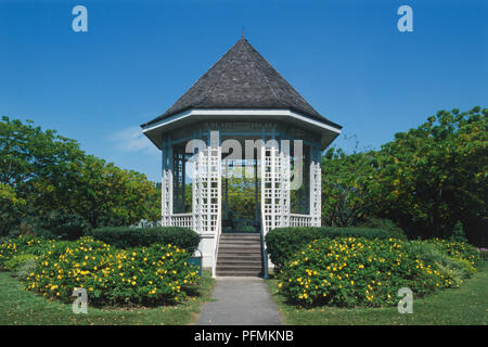 Singapur, botanischen Gärten, weiße Fliesen achteckige Musikpavillon mit braunen Dach, Hecken und Parklandschaft rund um, blaue Himmel. Stockfoto