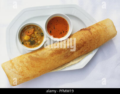 Dhosai, rollte ein Stück Papier - dünne Fladenbrot mit kleinen Gerichten serviert, was bedeutet, Linsensuppe sambar Curry, und Kokos Chutney. Stockfoto