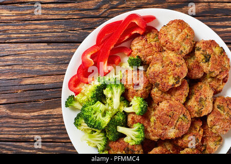 Im Ofen gebacken Broccoli saftiges Fleisch Frikadellen gefüllt mit geriebenen Käse auf weiße Platte auf alten Holztisch, gesunde niedrige Kalorien Rezept, Ansicht von abov Stockfoto