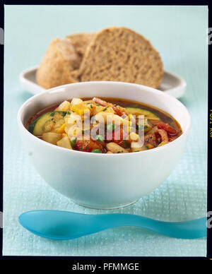 Schale, Minestrone, eine herzhafte italienische Suppe mit knusprigem Brot serviert, Seitenansicht Stockfoto