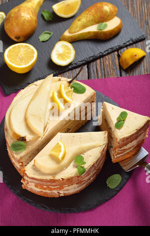 In der Nähe von köstlichen hausgemachten geschnitten Birne Biskuit mit Frischkäse, mit Minze, Birne und Zitrone auf schwarzem Schiefer Platte eingerichtet. Zutaten Stockfoto