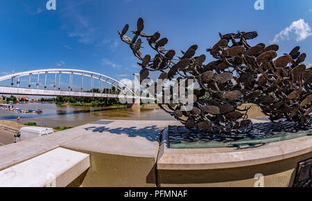 Die schönen Ufer der Theiß mit dem berühmten belvarosi hid-Brücke, auch als Downtown Bridge bekannt. Im Vordergrund steht eine Skulptur von Tag fliegen Stockfoto