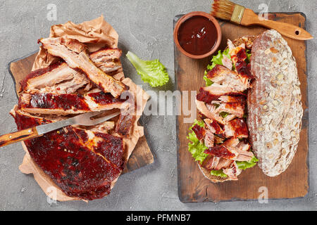 Lecker saftig riesen BBQ Rib Sandwich von Roggen Brotlaib mit Kopfsalat, entbeintes Fleisch in Scheiben geschnitten und leckere hausgemachte barbeque Sauce, Ansicht von oben Stockfoto