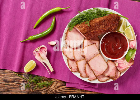 Köstliche Schinken gewürzt mit gemahlene Gewürze mit Barbecue Sauce, Kalk, Scheiben, Knoblauch und Dill auf weißen Teller am Tisch matte serviert, Ansicht von oben Stockfoto