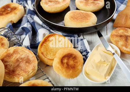 Warme Muffins in einer Pfanne, auf einem Raster und gerösteten Muffin ein Sandwich mit frischer Butter für das Frühstück zu kochen, Ansicht von oben, close-up Stockfoto