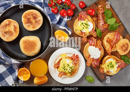 Eier Benedikt - geröstete Englische Muffins, gebratenen Speck, pochierte Eier und klassischen buttrige Sauce Hollandaise mit Orangensaft zum Frühstück serviert. Stockfoto