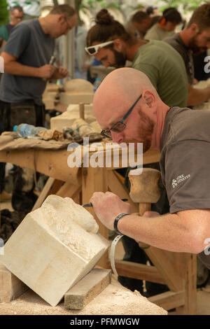 Der Steinmetz konzentriert sich auf das Schnitzen eines Steinblocks beim York Minster Stone Carving Festival, North Yorkshire, England, Großbritannien. Stockfoto