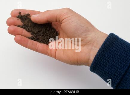 Person, sandigen Boden in der Hand, close-up Stockfoto