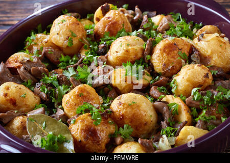 Hausgemachte Pan-Fried neue Kartoffeln mit Pilzen, Zwiebeln und Gewürze in einer Auflaufform, Ansicht von oben, close-up Stockfoto