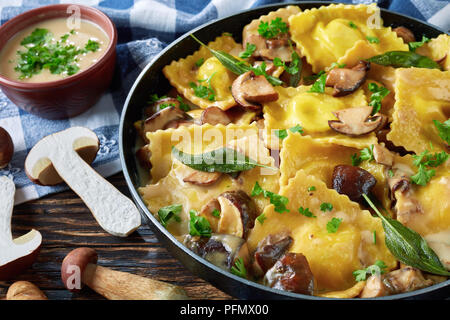 Hausgemachte Ravioli gefüllt mit Ricotta in cremiger Sauce Knoblauch Pilze in einer Pfanne gekocht, close-up Stockfoto