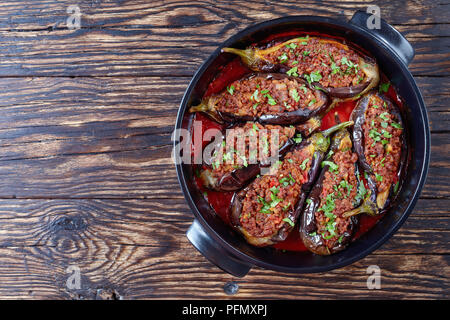 Hackfleisch und Gemüse gefüllte Auberginen Auberginen in einem schwarzen Auflaufform auf einem alten rustikalen Tisch, türkische Küche, horizontale Ansicht von oben Stockfoto