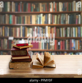 Stapel von Vintage Books mit offenen auf Holzregal in Bibliothek Stockfoto