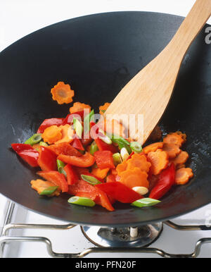 Close-up von Paprika und Gemüse und einem Holzspachtel in einem Wok. Stockfoto