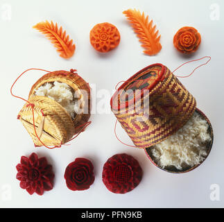 Khao Niaw, traditionelle Thailändische klebriger Reis in Lidded Körbe und Blatt und Blüte geformt Gemüse, Ansicht von oben Stockfoto