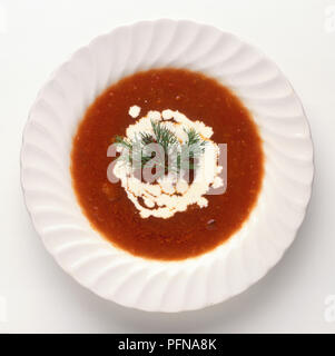 Solyanka, einem traditionellen Russischen, Tomaten Suppe mit Sauerrahm und Dill garnieren, Ansicht von oben Stockfoto
