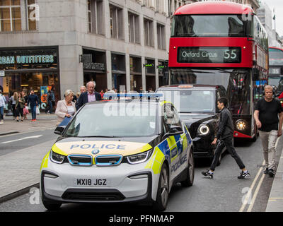 London, Großbritannien. 22 August, 2018. Teil der Bemühung, die Luft in der Oxford Street zu reinigen beinhaltet die Einführung von Elektro- oder Hybridfahrzeuge - in diesem Fall ein BMW elektrische Polizei Auto, eine der neuen elektrischen schwarzen Londoner Taxis und ein hybrid Double Decker London Bus. London, 22. Aug 2018. Credit: Guy Bell/Alamy leben Nachrichten Stockfoto